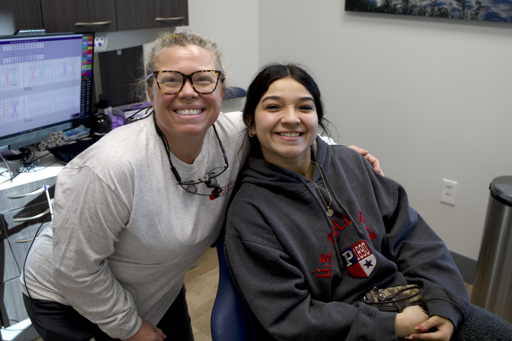 Dentist and patient smiling together in a modern dental office.